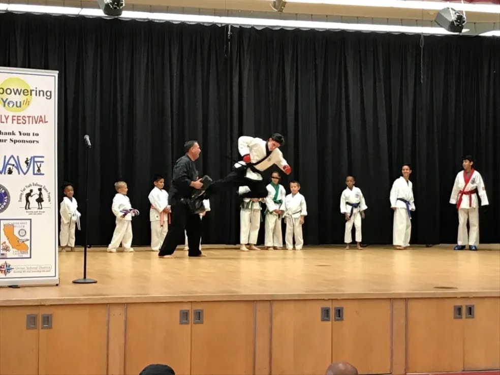 Martial arts demonstration jump kick on stage at youth festival