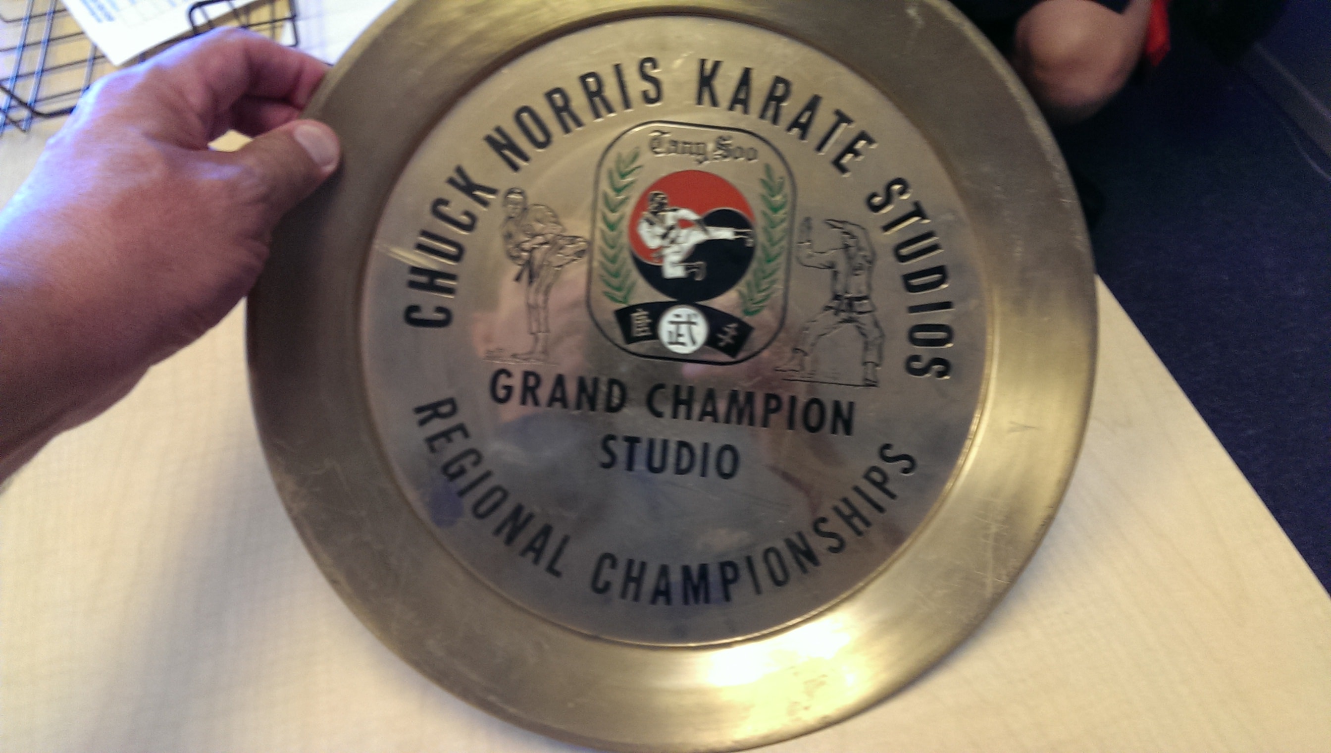 Man in suit holding red Chuck Norris Karate Senior Competitor of the Year award