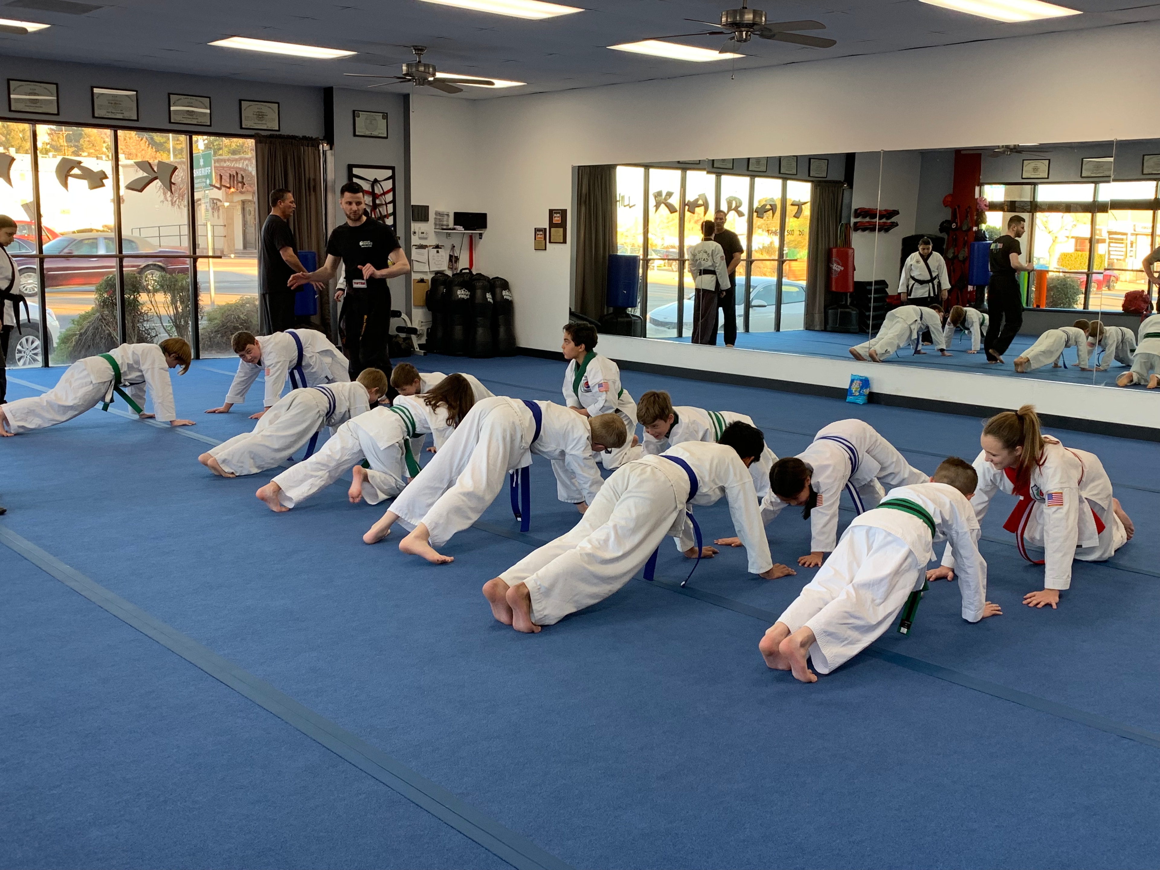 Karate students doing push-ups in dojo class