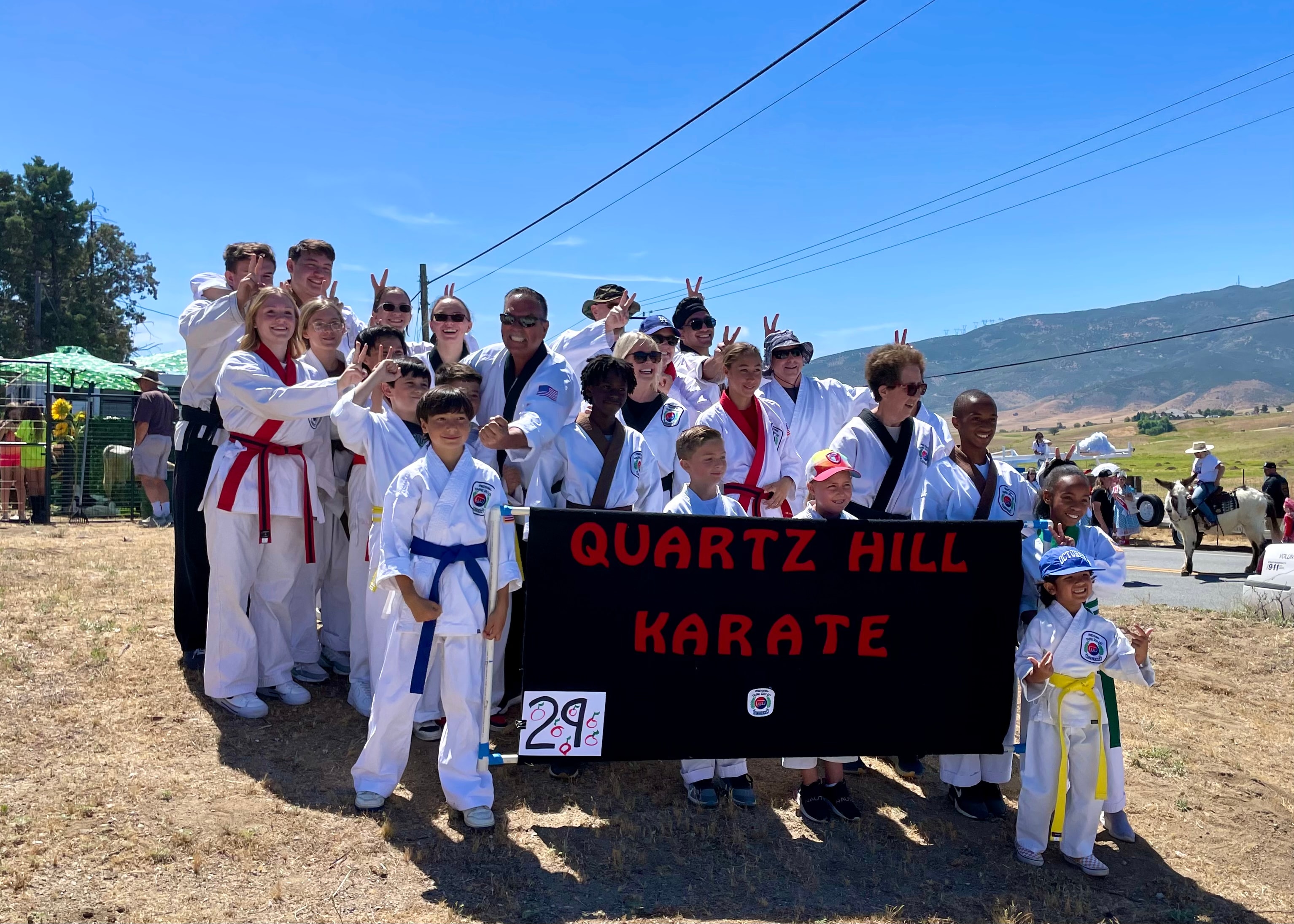 Quartz Hill Karate group photo outdoors with banner at community event